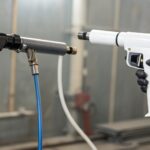 Modern professional powder coating gun with sleek ergonomic design spraying an even coat on a metal surface, illustrating precision and efficiency improvements over older models