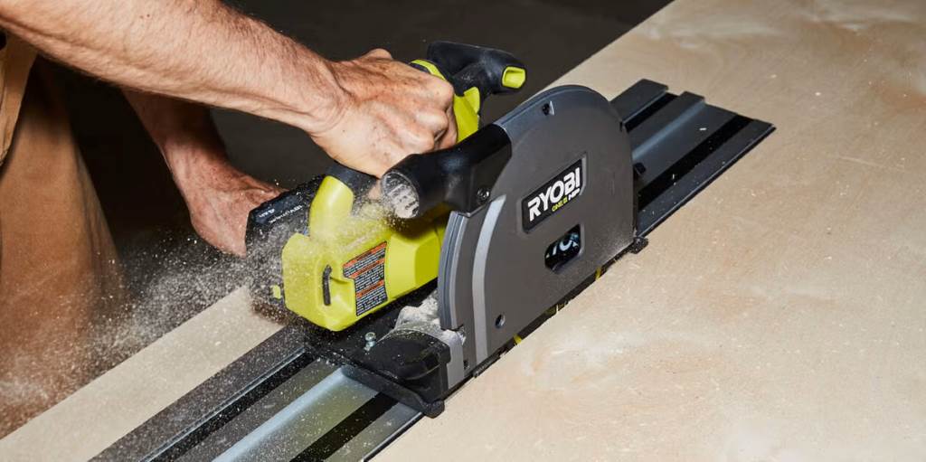 A DIY enthusiast using the Ryobi One+ circular saw to frame a wooden deck, with safety gear and tools scattered around.