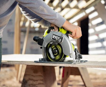 A close-up of the Ryobi One+ circular saw blade mid-cut on plywood, showcasing its precise LED guide line
