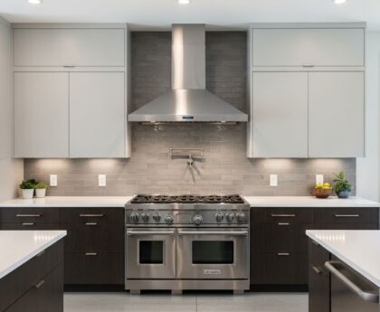 Modern stainless steel range hood with low noise motor installed above gas cooktop in contemporary kitchen design