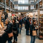 Shoppers browsing handmade jewelry and ceramic gift displays at the One of a Kind Show Chicago 2026 inside The Mart on December 3 to 6